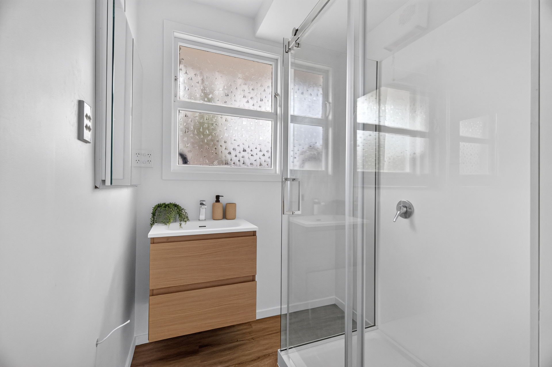 Bright renovated bathroom with timber vanity at 1A Quinns Road